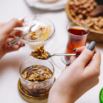 man takes walnut jam in saucer tea side view